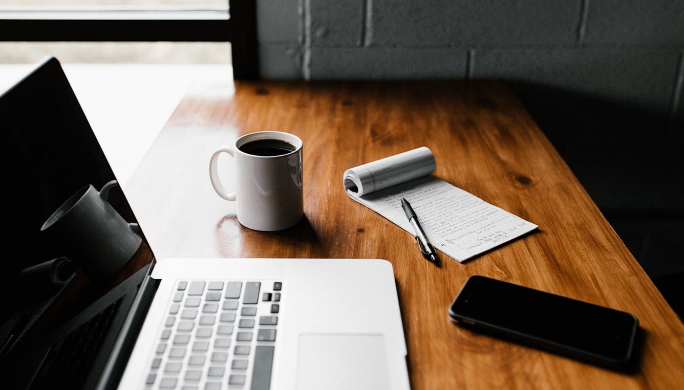 close up of a desk and a coffee and phone